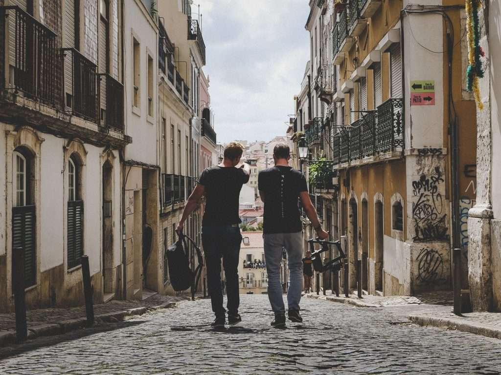 two guys walking down brick road